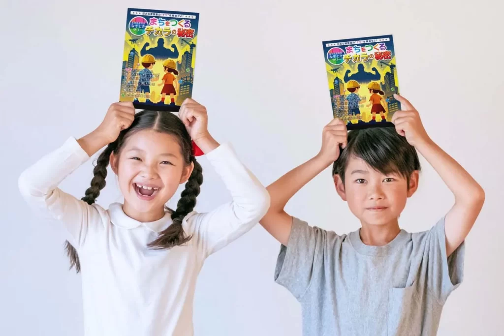 謎解きハンドブックを持つ女の子と男の子