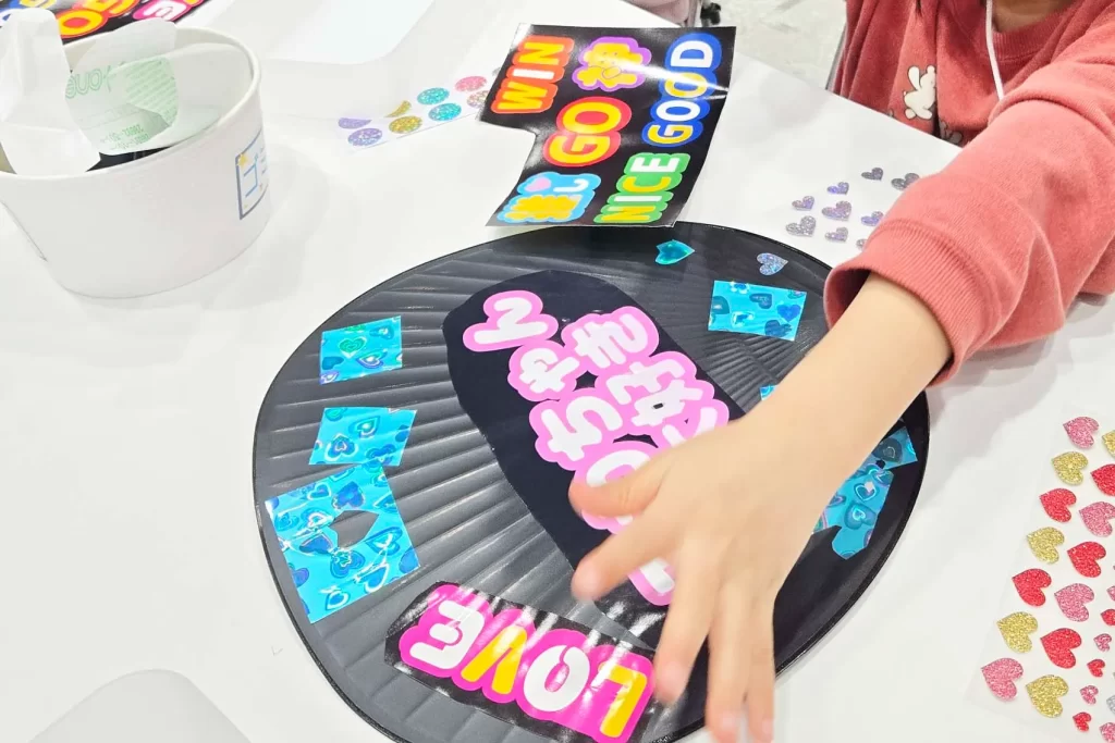 女の子が「推し活うちわ」を工作する様子