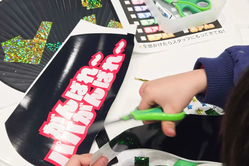 パパがんばれ～と書かれたシールを切る男の子