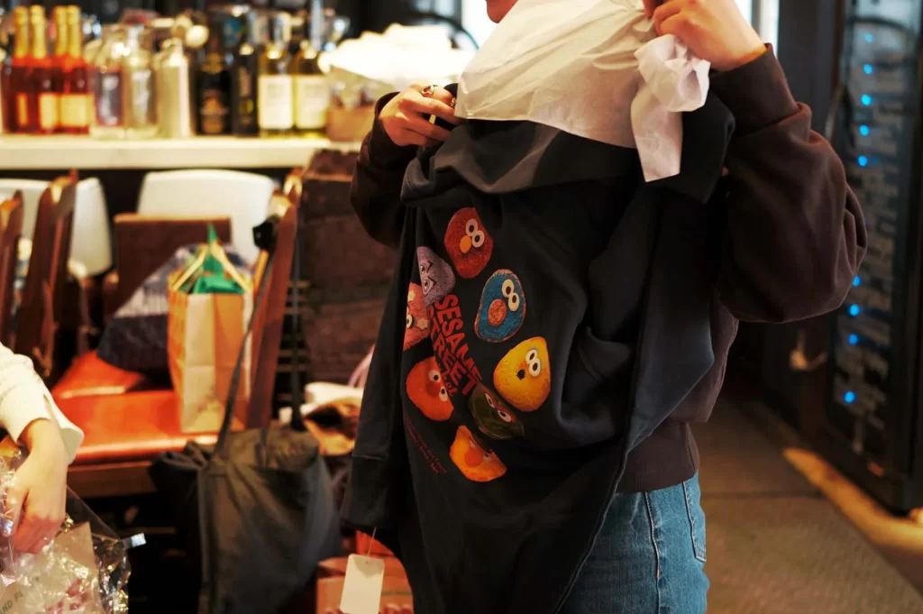 セサミストリートのパーカーを持つ女性