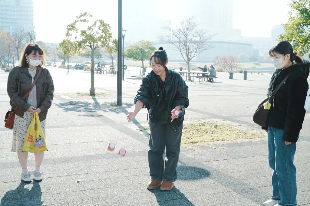 サイコロを投げるピコトンスタッフの女性