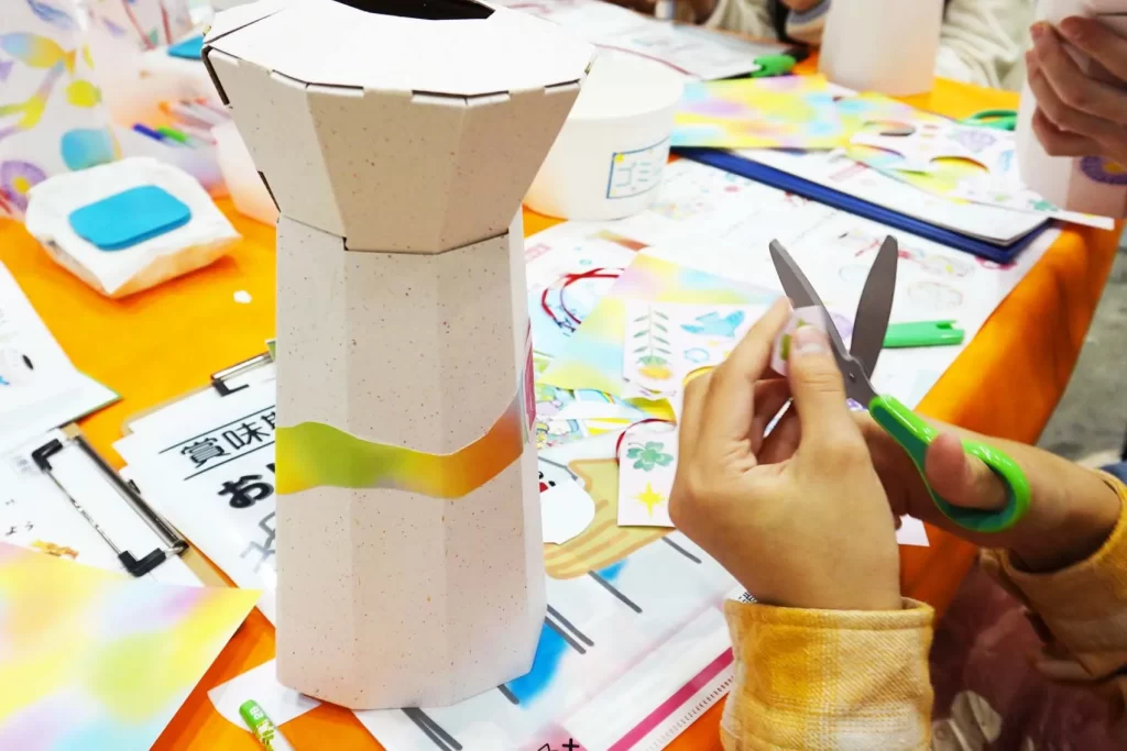 エコプロ2025で実施した「リサイクル・フラワーベース」を工作する女の子の手元