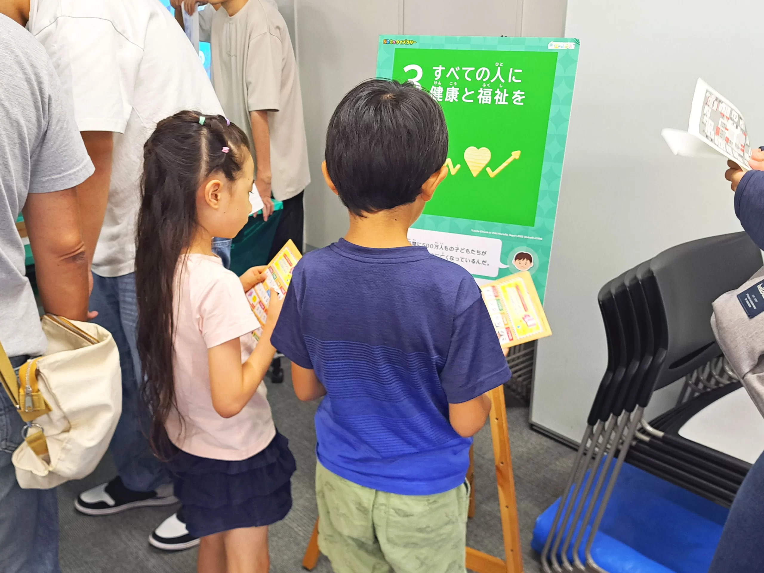 「あつぎSDGsフェスティバル」で開催された『SDGsクイズラリー』で「2 すべての人に健康と福祉を」のパネルの前でクイズを楽しむ子供