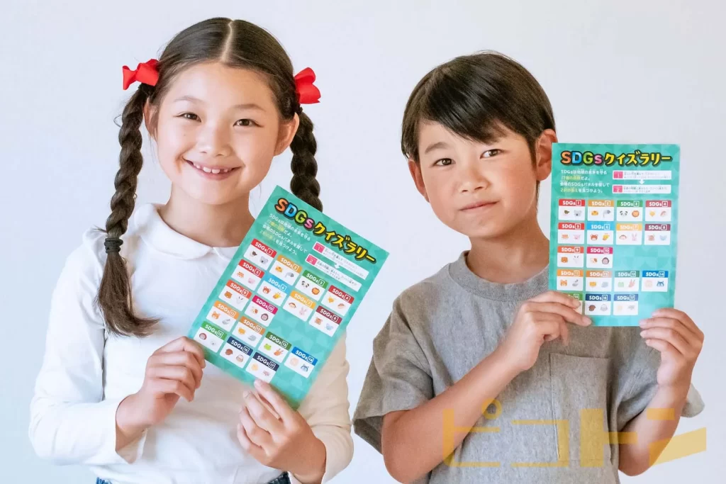 SDGsクイズラリーのカードを持つ女の子と男の子