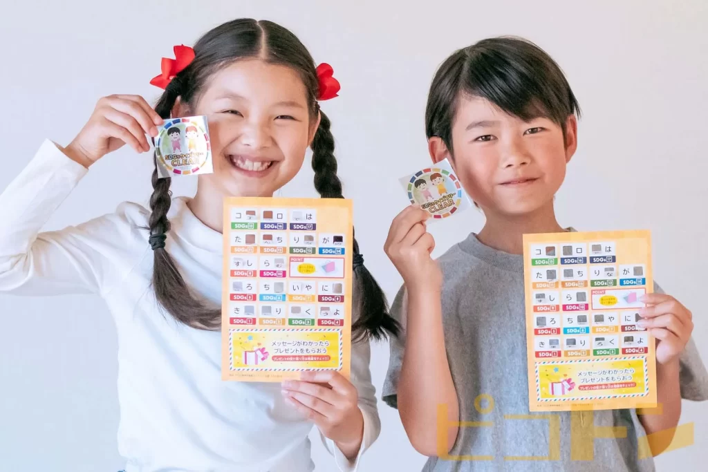 SDGsクイズラリーのカードとシールを持つ女の子と男の子