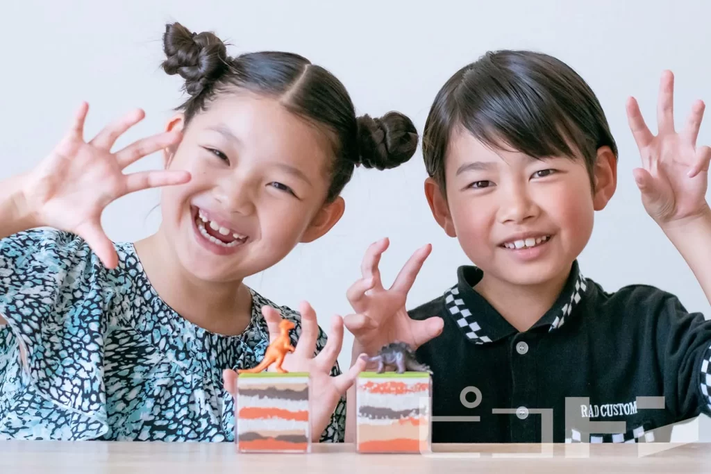 完成した地層ジオラマとポーズをする女の子と男の子