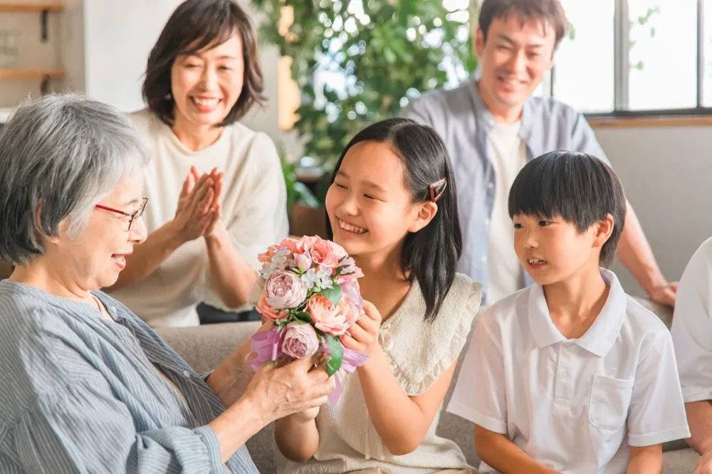 夏といえば? 行事やアイデア22選を紹介する記事のおばあさんに花束を渡す女の子の写真