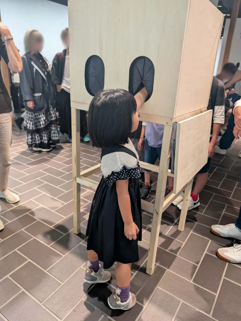 東京都美術館「つくるよろこび 生きるためのDIY」でボックスの中に手を入れる女の子