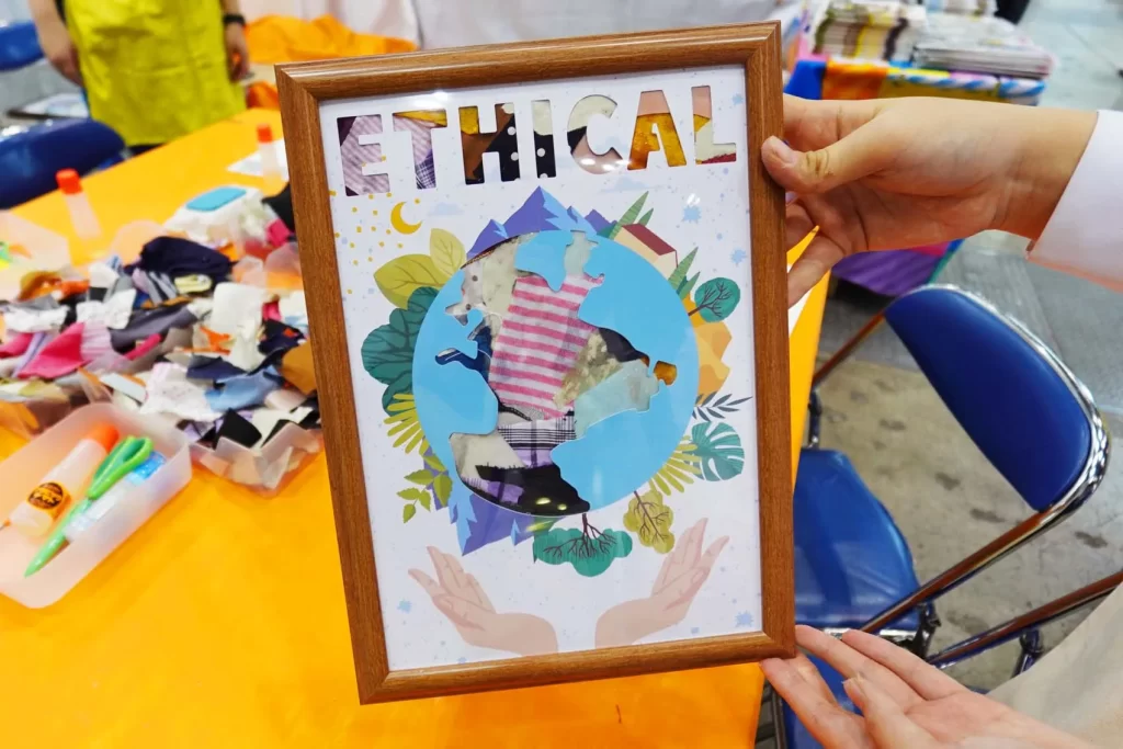 エコプロ2025で実施した「アップサイクル・ウォールアート」の完成品を持つ参加者の女性の手元