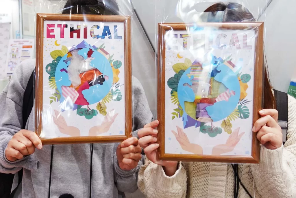 エコプロ2025で実施した「アップサイクル・ウォールアート」の完成品を持つ参加者の女性2名