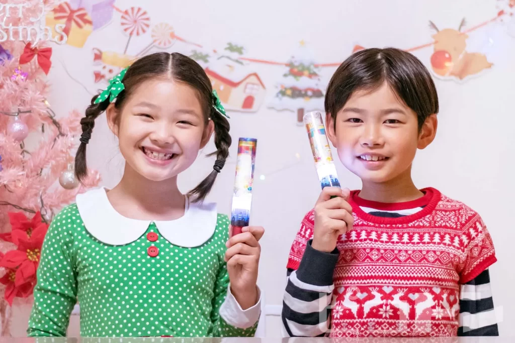 『光る！ウォータースティックライト クリスマスver.』を持った女の子と男の子