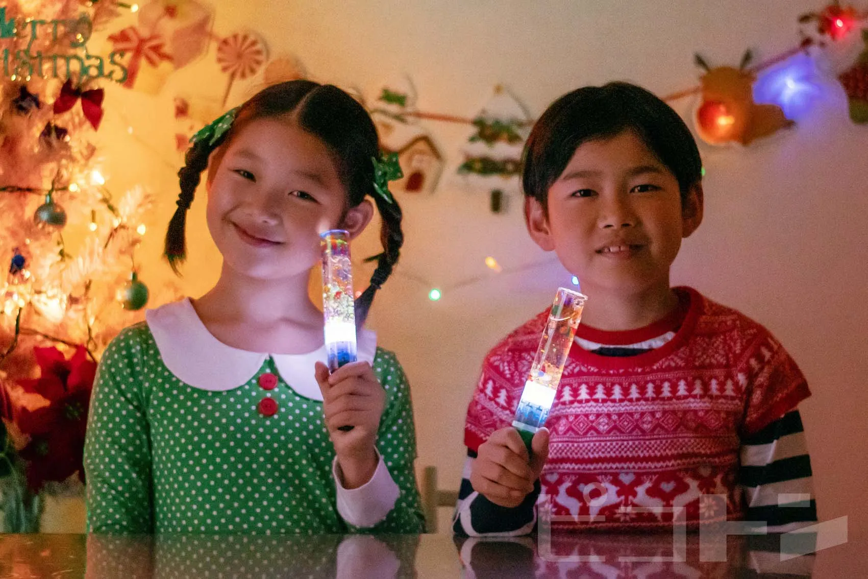 完成した『光る!ウォータースティックライト クリスマスver.』を手にした女の子と男の子