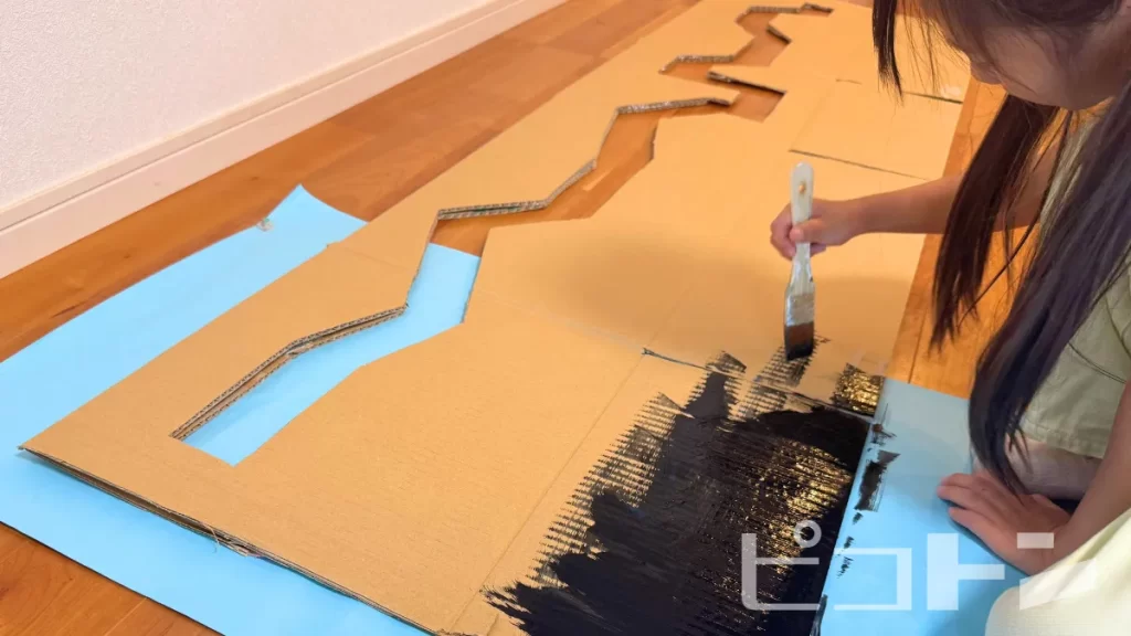 ダンボールに色を塗っているところ