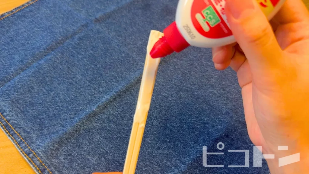 割り箸にボンドをつけている