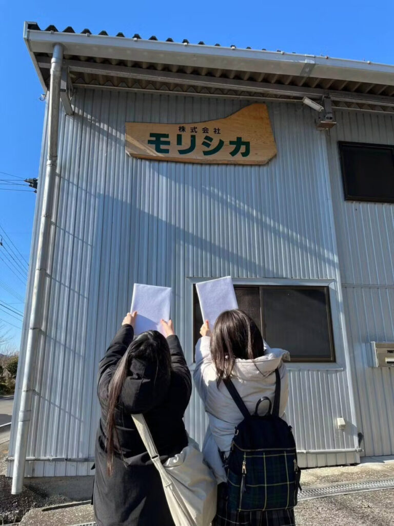 株式会社モリシカ様の前で写真を撮るSaayaさんとYuiさん